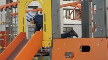 Küçük çocuk çocuk parkında kayıyor. Çocuk gelişimi, spor ve eğitim kavramı.