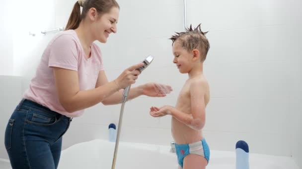 Niño pequeño sonriendo a la madre mientras ella lo está lavando en el baño. Concepto de hygine, desarrollo infantil y diversión en casa — Vídeos de Stock