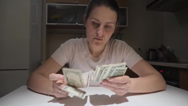 Finansal sorunları olan stresli bir kadın kafasını tutuyor ve hayal kırıklığına uğramış hissediyor. Mali zorluklar, iflas, vergiler ve kira ödemeleri kavramı. — Stok video
