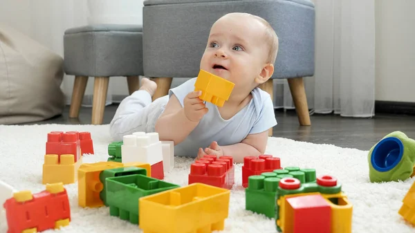 Портрет милого мальчика, играющего с игрушечными кирпичами и блоками дома — стоковое фото