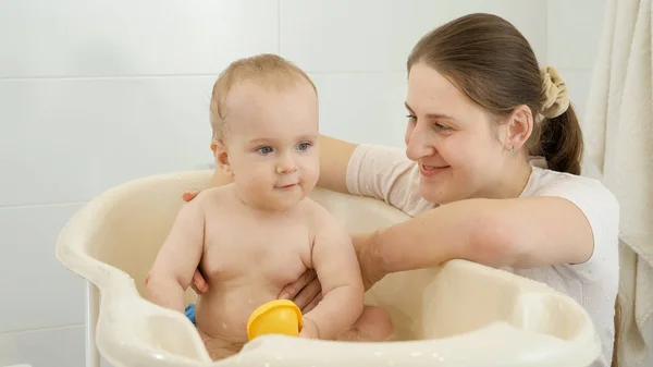 Retrato de la madre sonriente con su hijo pequeño lavándose en el baño — Foto de Stock