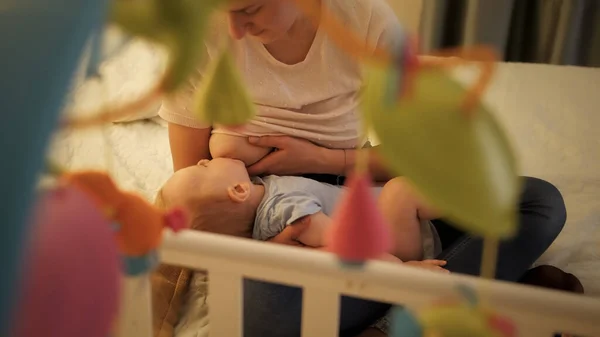 Close-up da mãe amamentando seu filho bebê na cama à noite — Fotografia de Stock