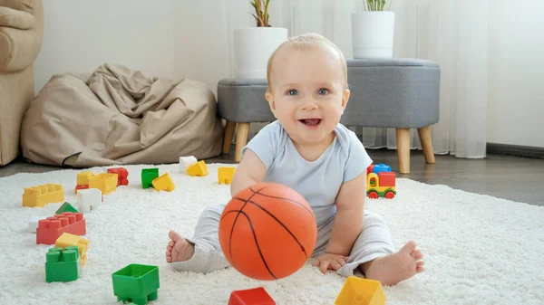 Szczęśliwy uśmiechnięty chłopiec gra w koszykówkę z rodzicem na dywanie w domu. Koncepcja rozwoju dzieci, sportu, edukacji i kreatywności w domu — Zdjęcie stockowe