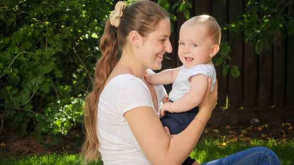 Szczęśliwy uśmiech 9 miesięcy chłopiec z uśmiechnięta matka zabawy razem w ogrodzie — Zdjęcie stockowe