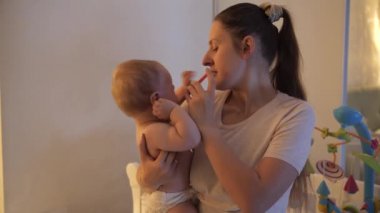 Genç anne oğluna şırınga ya da göz damlası ile ilaç veriyor. Çocuk sağlığı, iyileşme, tedavi ve hastalık kavramı.