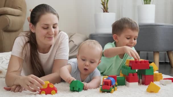 Allegro sorridente famiglia godendo di giocare giocattoli e divertirsi sul tappeto insieme a casa. Concetto di famiglia che ha tempo insieme e sviluppo dei bambini — Video Stock