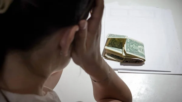 Stresszes nő ül az íróasztal mögött, és keres kevés pénzt bankjegyek fizetni bérleti hitel — Stock Fotó