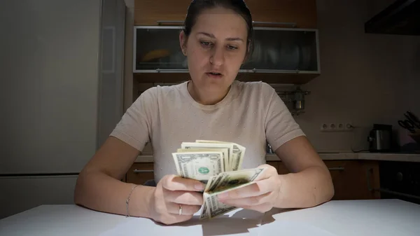 A stresszes és aggódó nő portréja, aki éjszakánként a konyhán számolja a pénzét. — Stock Fotó
