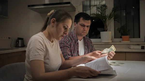 Vystresovaná mladá rodina dostává oznámení o bankovním dluhu a počítá své peníze — Stock fotografie