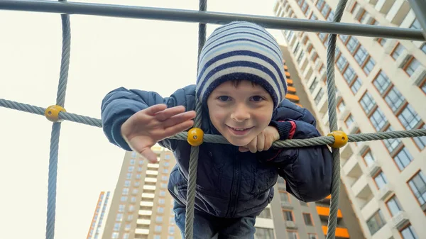 Retrato de bonito sorrindo menino jogar no playground e acenando mão na câmera — Fotografia de Stock