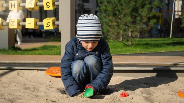 Küçük çocuk soğuk bir sonbahar günü parkta oyun oynuyor ve eğleniyor. — Stok fotoğraf
