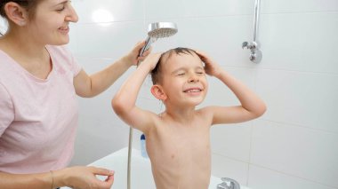 Annesiyle banyo yapan ve duş alan küçük bir çocuk. Hijyen kavramı, çocuk gelişimi ve evde eğlence
