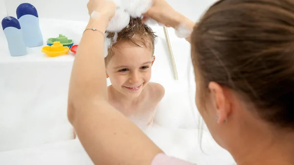Annenin oğluyla banyoda oynayıp onu şık bir saç kesimi yaparken çekilen komik bir fotoğraf. — Stok fotoğraf