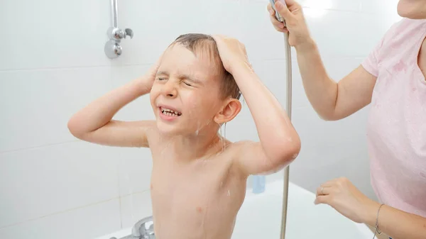 Portré kisfiúról, aki becsukja a szemét, miközben zuhanyozik a fürdőszobában. — Stock Fotó