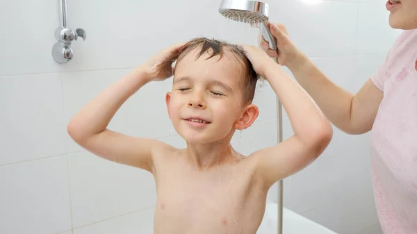 Retrato de niño pequeño lavando champú bajo la ducha en el baño — Foto de Stock