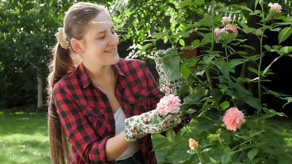 Mutlu gülümseyen kadın bahçıvan bahçede çiçek yetiştiriyor. — Stok fotoğraf