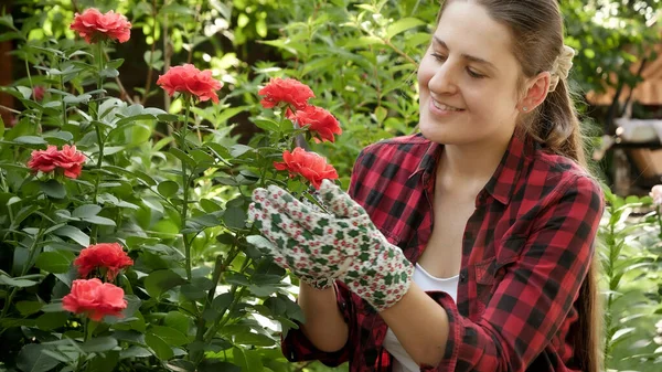 Retrato de una joven sonriente que trabaja en el jardín. Cortar hojas muertas y quitar pétalos de rosa. Jardinería hobby y cultivo de plantas — Foto de Stock