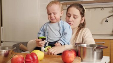 Ağlayan küçük çocuk, annesinin ona verdiği yemek yüzünden üzgün. Sağlıklı beslenme, diyet ve çocuk maması kavramı.