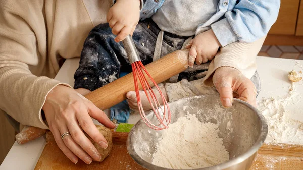 Zbliżenie małego chłopca ugniatającego ciasto i mąkę w misce do pieczenia chleba z matką. Pojęcie małego kucharza, dzieci gotujące jedzenie, zdrowe odżywianie. — Zdjęcie stockowe