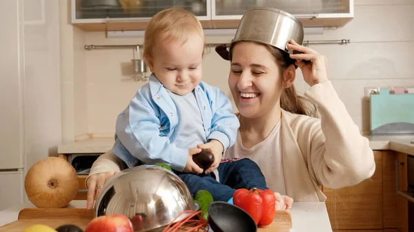 Divertente colpo di madre e bambino bambino che gioca con padelle e pentole in cucina — Foto Stock