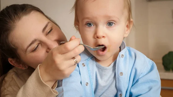 Retrato de un niño pequeño abriendo la boca mientras come gachas con cuchara. Concepto de pequeño chef, niños cocinando alimentos, nutrición saludable — Foto de Stock