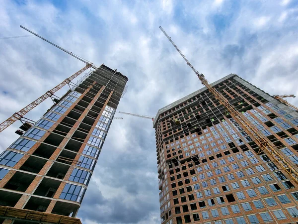 View from the ground buidling site of modern buidlings and working construction cranes — Stock Photo, Image