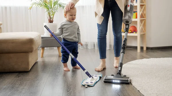 Little baby boy helping his mother doing cleanup at house — Stock Photo, Image