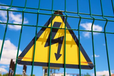 Elektriksel tehlike işareti metal bir çite yerleştirilmiş..