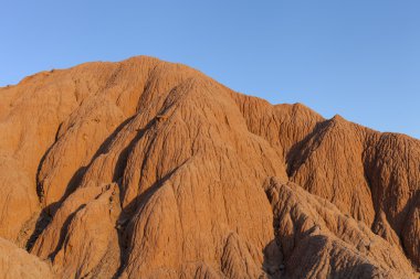 Red sandy hill against the blue sky clipart
