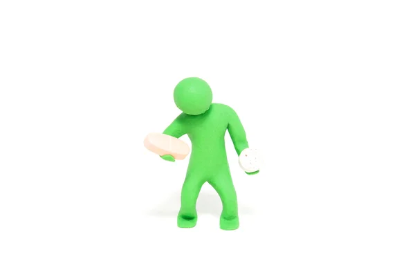Pequeno fantoche de plasticina verde contém comprimidos — Fotografia de Stock
