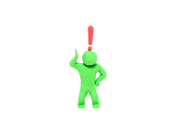 Small green plasticine puppet with a exclamation mark over the head — Stock Photo, Image