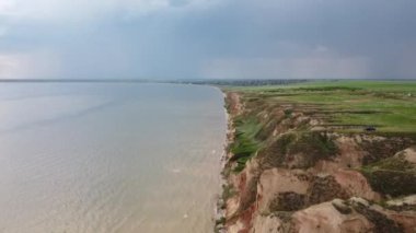 İnsansız hava aracı tepelerin üstündeki Dinyeper Nehri 'nin üzerinden günbatımı gökyüzünün arka planına doğru uçuyor.