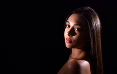 Çıplak omuzlu güzel bir genç kadının portresi, siyah arka planda izole edilmiş, metin için yeri var.