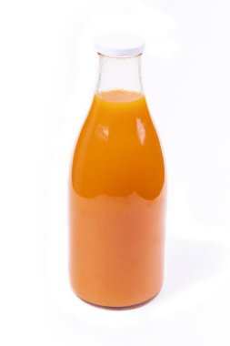 Beyaz arka plan. İçinde portakal suyu olan cam bir şişe. Mandalina suyu, havuç ve balkabağı..