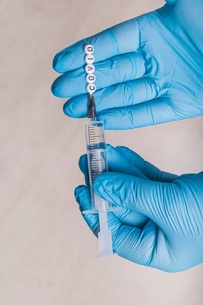 这个女孩是一名戴着蓝色手套的医生 手里拿着注射器 注射了这种疾病的疫苗 针头上有儿童玩具信 上面有题词 — 图库照片