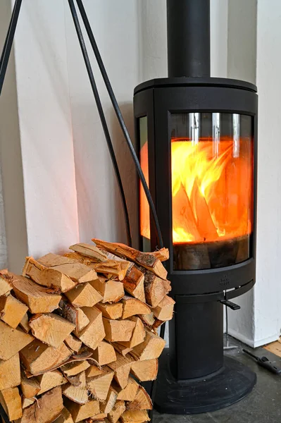 Pile of firewood and hot burning stove — стоковое фото