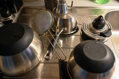 Mutfak malzemesi lavaboda duruyor. Yıkandıktan sonra kurulanıyor.