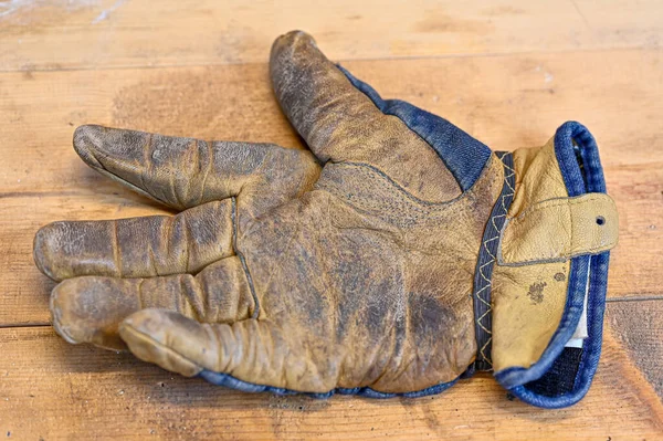 Робоча рукавичка з джинсом, лежить на дерев'яній лавці — стокове фото