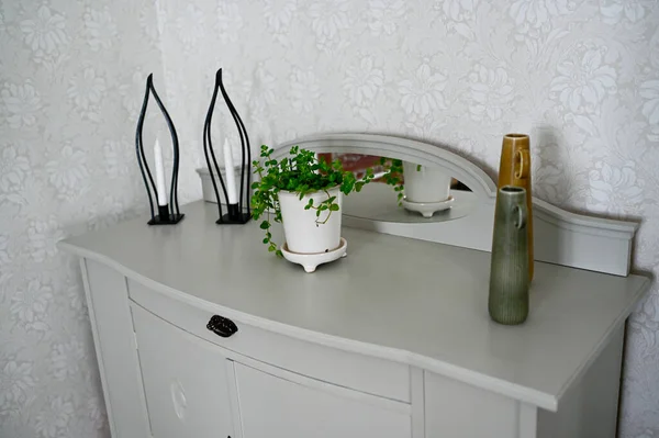 Oud dressoir grijs geschilderd met daarop bloemen en kaarsen — Stockfoto