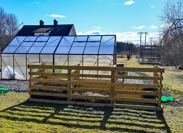 Serre de compost et maison dans le jardin printanier — Photo