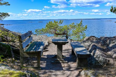 30 Nisan 2022 'de Vattern Motala Gölü' ne bakan iki banklı bir masa.