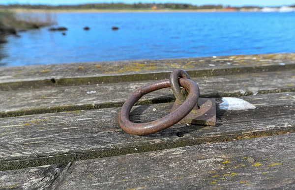 Old jetty with round rusty mooring ring — Fotografia de Stock