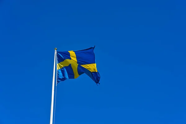 Švédská Vlajka Modrém Žlutým Křížem Proti Jasně Modré Obloze — Stock fotografie