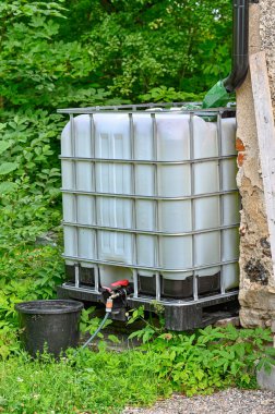 rainwater with big cubic tank with black bucket Kumla Sweden july 11 2022