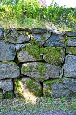 big old wall made of stones covered in moss Karlslund garden Orebro august 4 2022