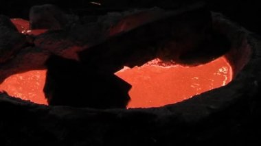 Bir çan üretim fabrikasının fırınında erimiş metal. Kapat..  