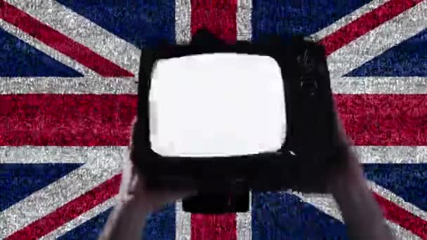 手黒の生活の上に古いテレビを持ち上げる英国の旗の物質のロゴ — ストック動画