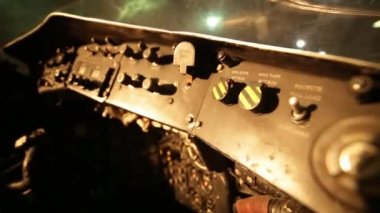Arka planda harici ışıkları olan eski bir bombacının içindeki yan kontrol panelleri. Kapat.. 