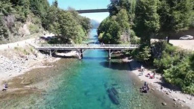 Arjantin 'in Neuquen Eyaleti, Nahuel Huapi Ulusal Parkı' ndaki Villa la Angostura 'da bir yaya köprüsünde insanlar. Drone Görüntüleri. 4K Çözünürlüğü.