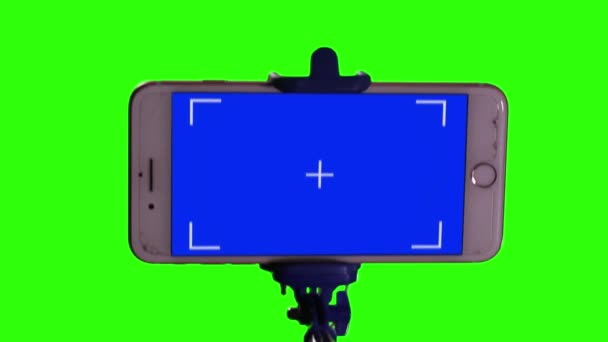 緑の画面に対してセルフィースティックとブルースクリーンとスマートフォン 閉鎖中だ 緑の画面と青の画面を必要な映像や画像に置き換えることができます Effectsやその他のビデオ編集ソフトウェアのキーエフェクトで実行できます — ストック動画